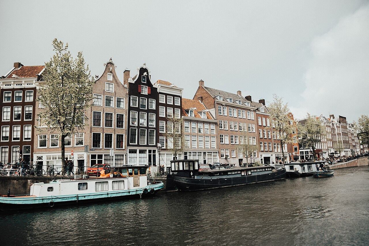 Amsterdam canal houses and moored boats beside the water