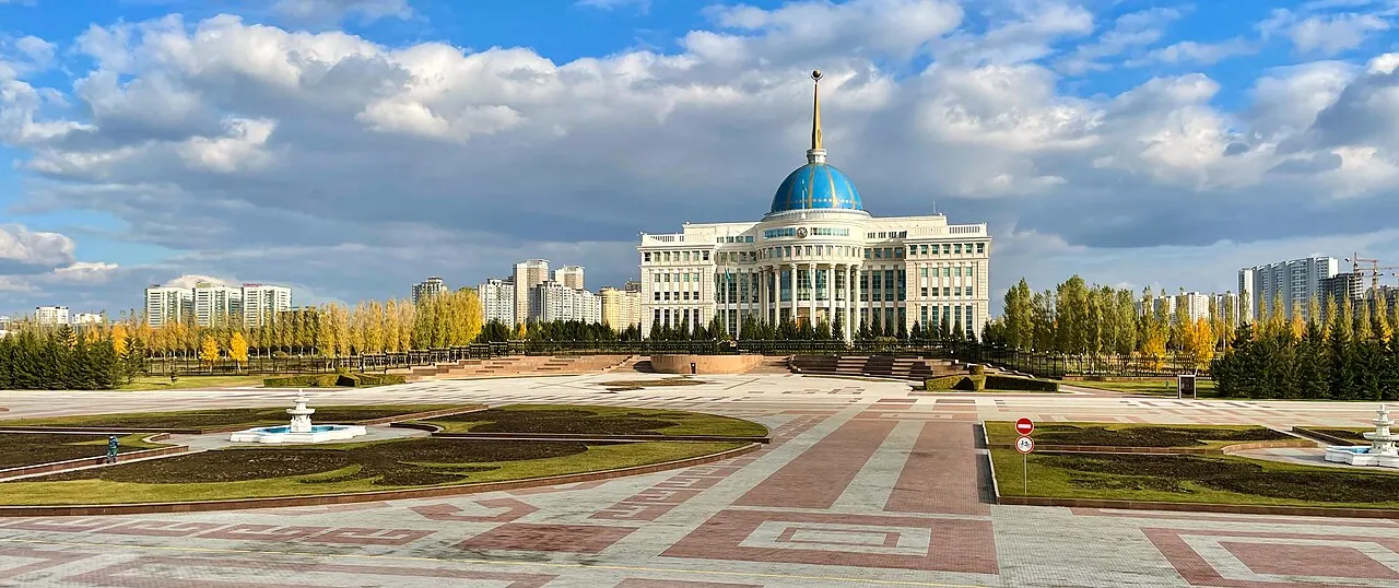 Ak Orda's blue dome and white facade behind its formal approach