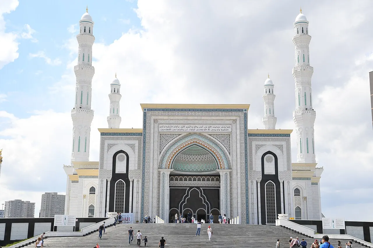 The white facade, entrance arches and minarets of Hazrat Sultan Mosque