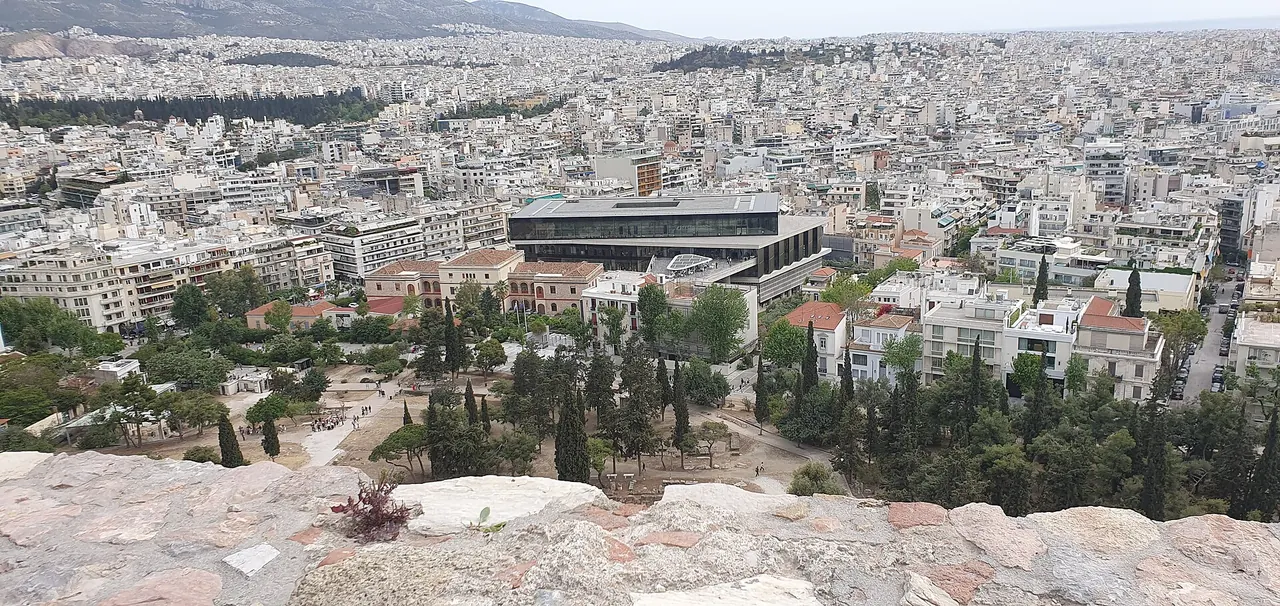 The Acropolis Museum building in the Athens cityscape below the Acropolis