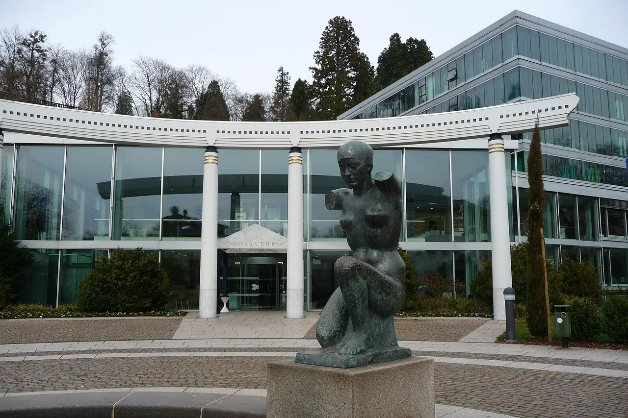 The glazed entrance of Caracalla Spa with a sculpture in front