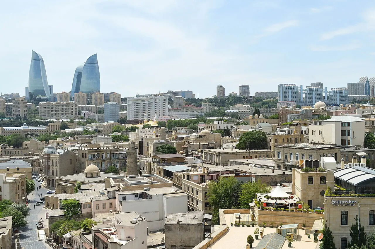 The three Flame Towers rising above the rooftops and hills of Baku