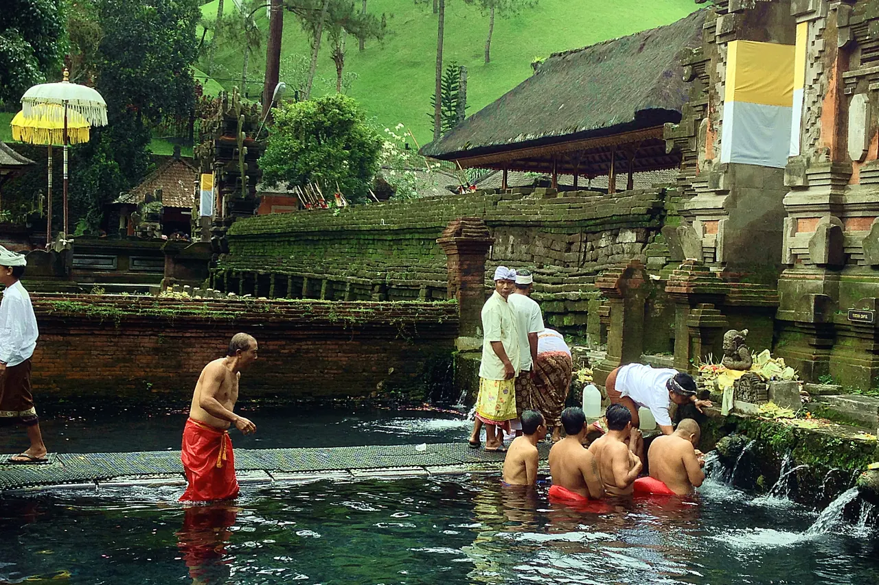 Visitors at the stone bathing fountains in Tirta Empul temple