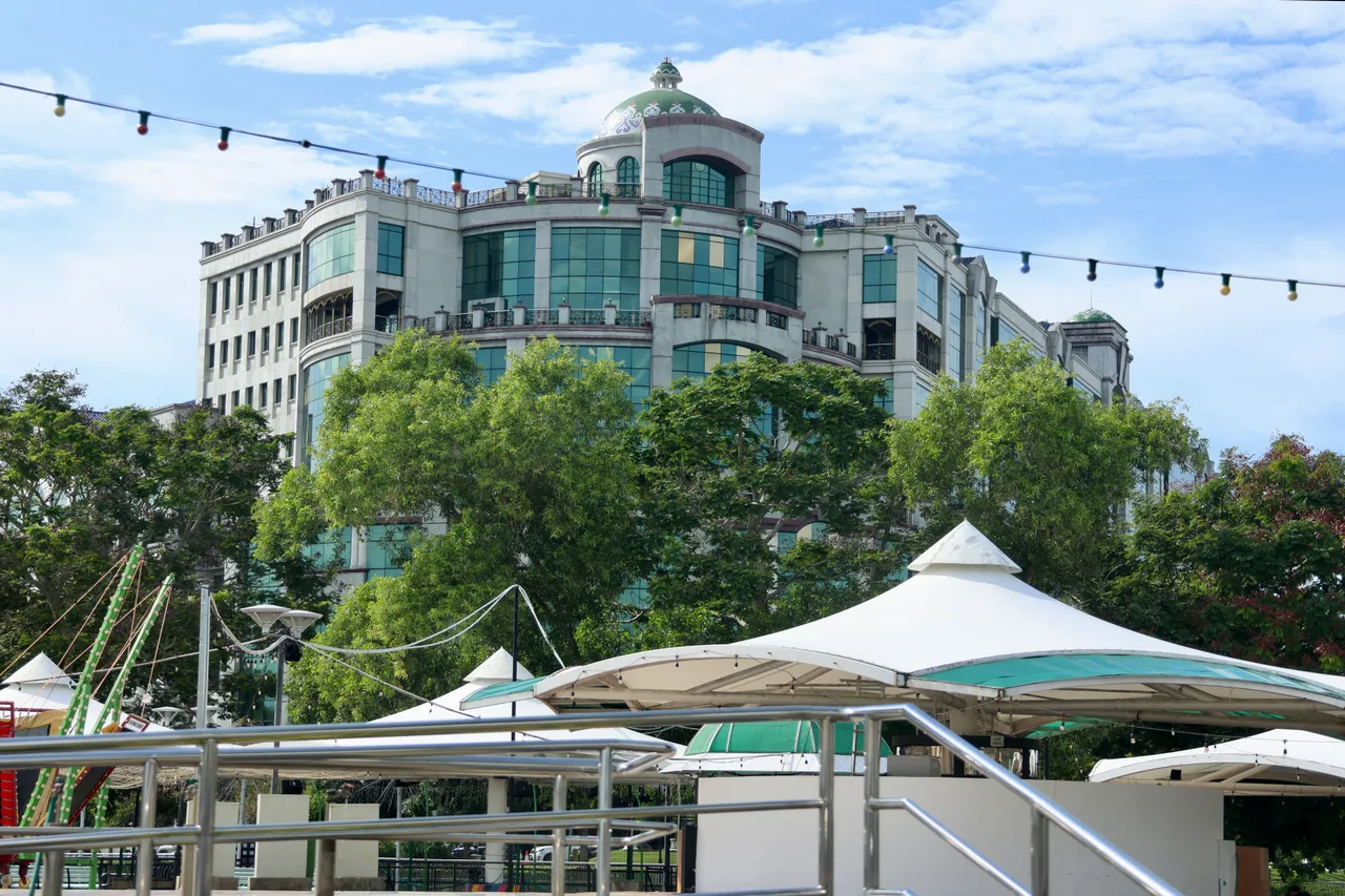 Gadong Night Market canopies with the Rizqun hotel building behind them, photographed in daylight