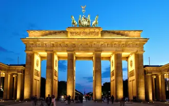 The Brandenburg Gate and its Quadriga illuminated against the evening sky