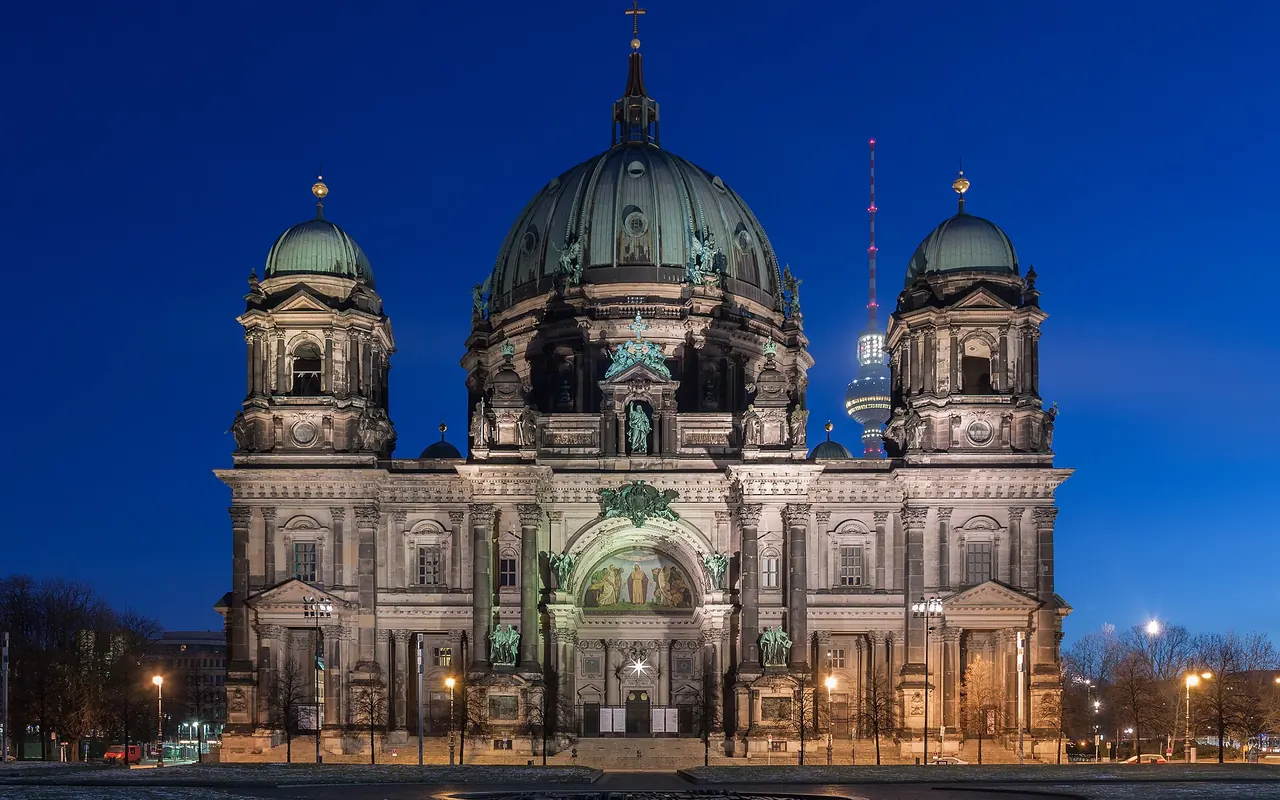 Berlin Cathedral's domes illuminated above the Lustgarten at night