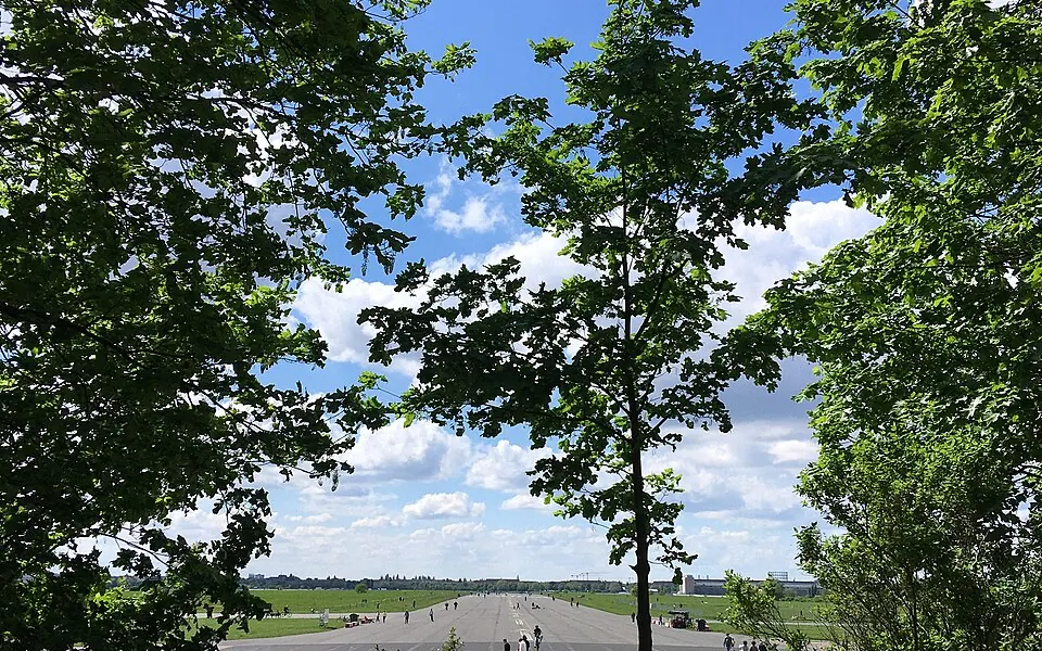 A former runway at Tempelhofer Feld, framed by trees beneath an open sky