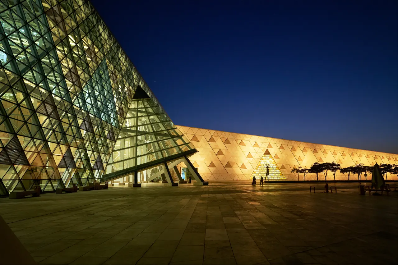 The illuminated glass exterior of the Grand Egyptian Museum in Giza