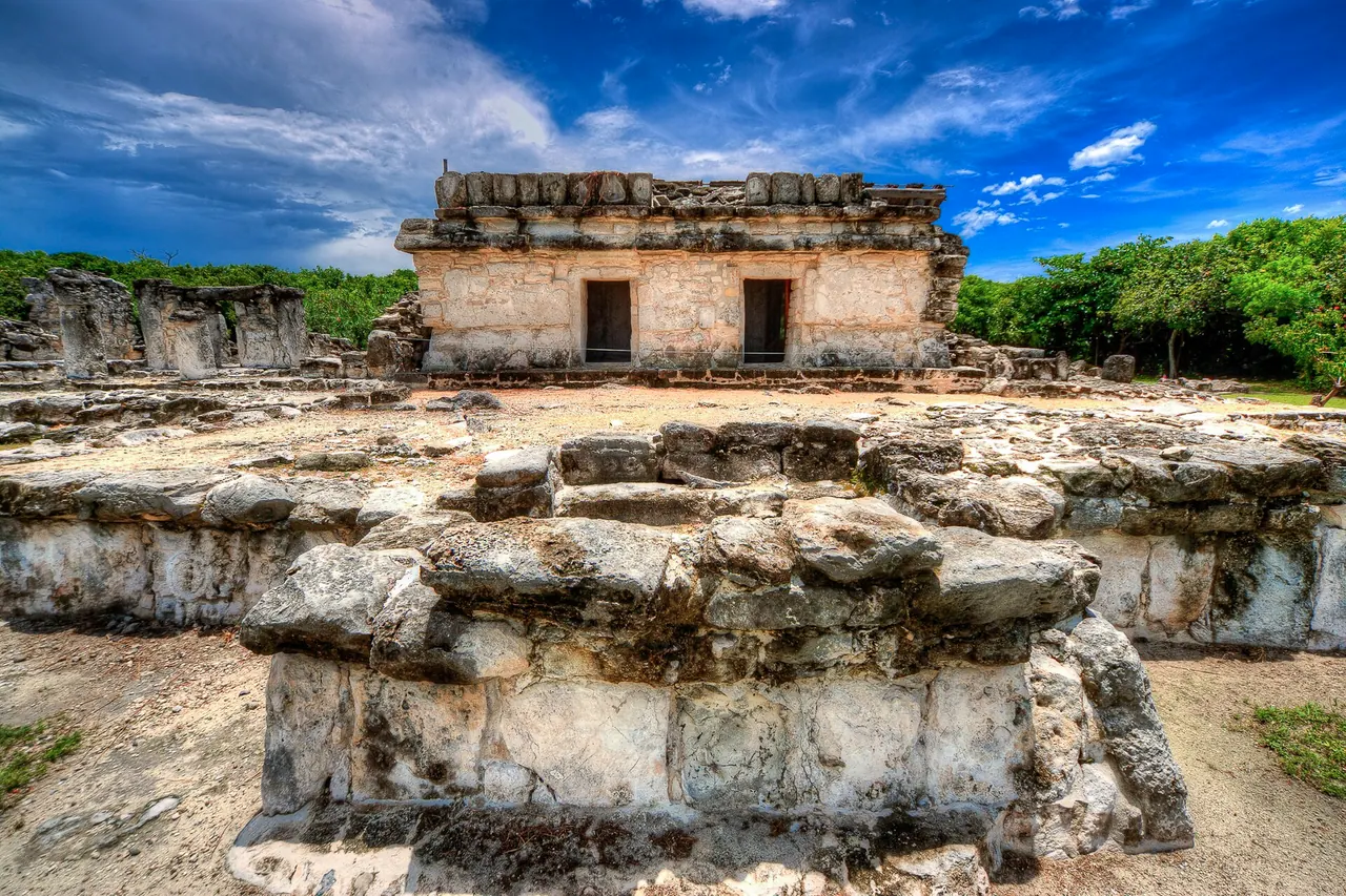 Low stone platforms and a surviving building at El Rey in Cancun