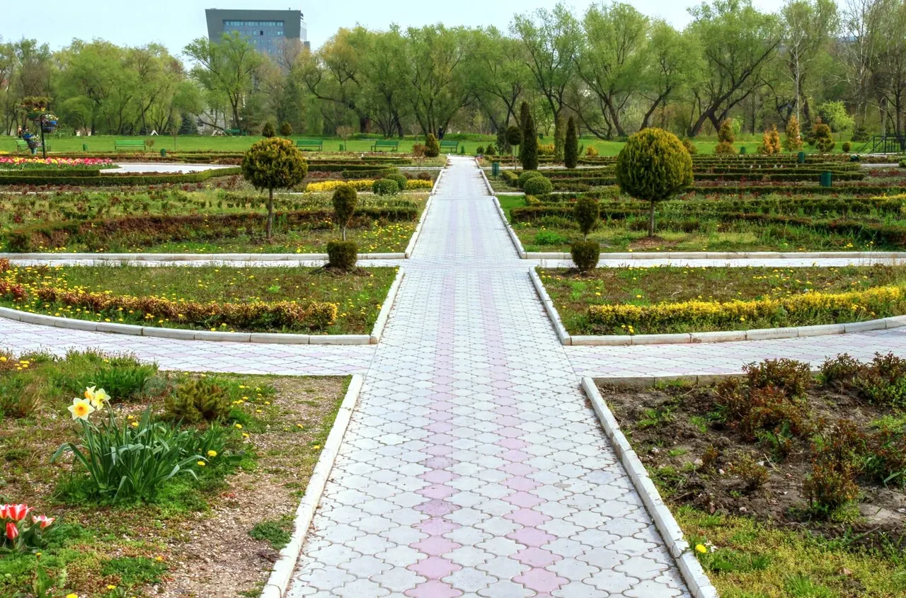 Allée sinueuse, pelouses et arbres adultes dans le parc Dendrarium de Chișinău