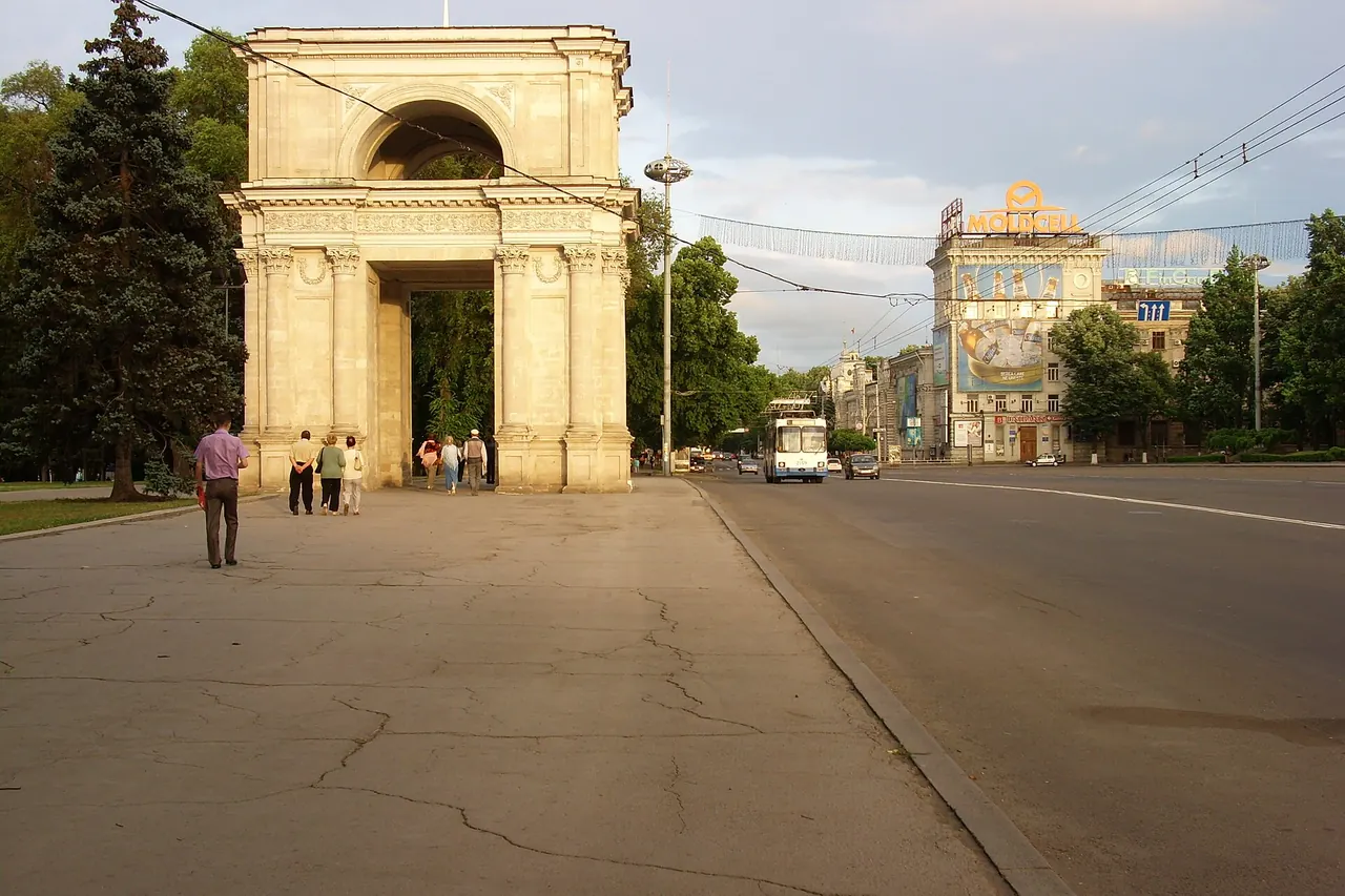 Der helle steinerne Triumphbogen im Zentrum von Chișinău mit der Uhr über den Öffnungen