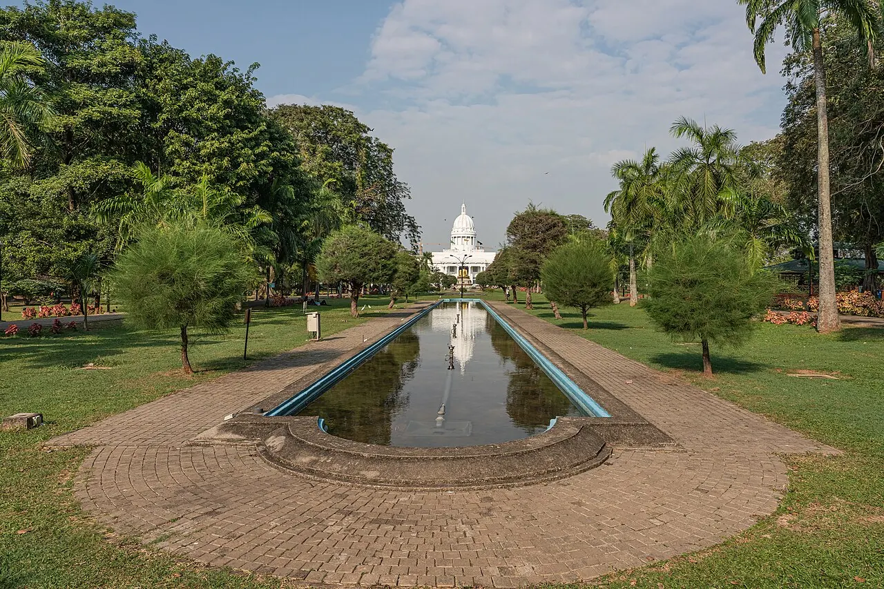 Ein Wasserbecken und baumgesäumte Wege im Viharamahadevi Park