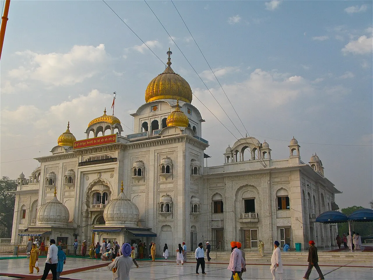 The white facade and golden domes of Gurudwara Bangla Sahib in central Delhi