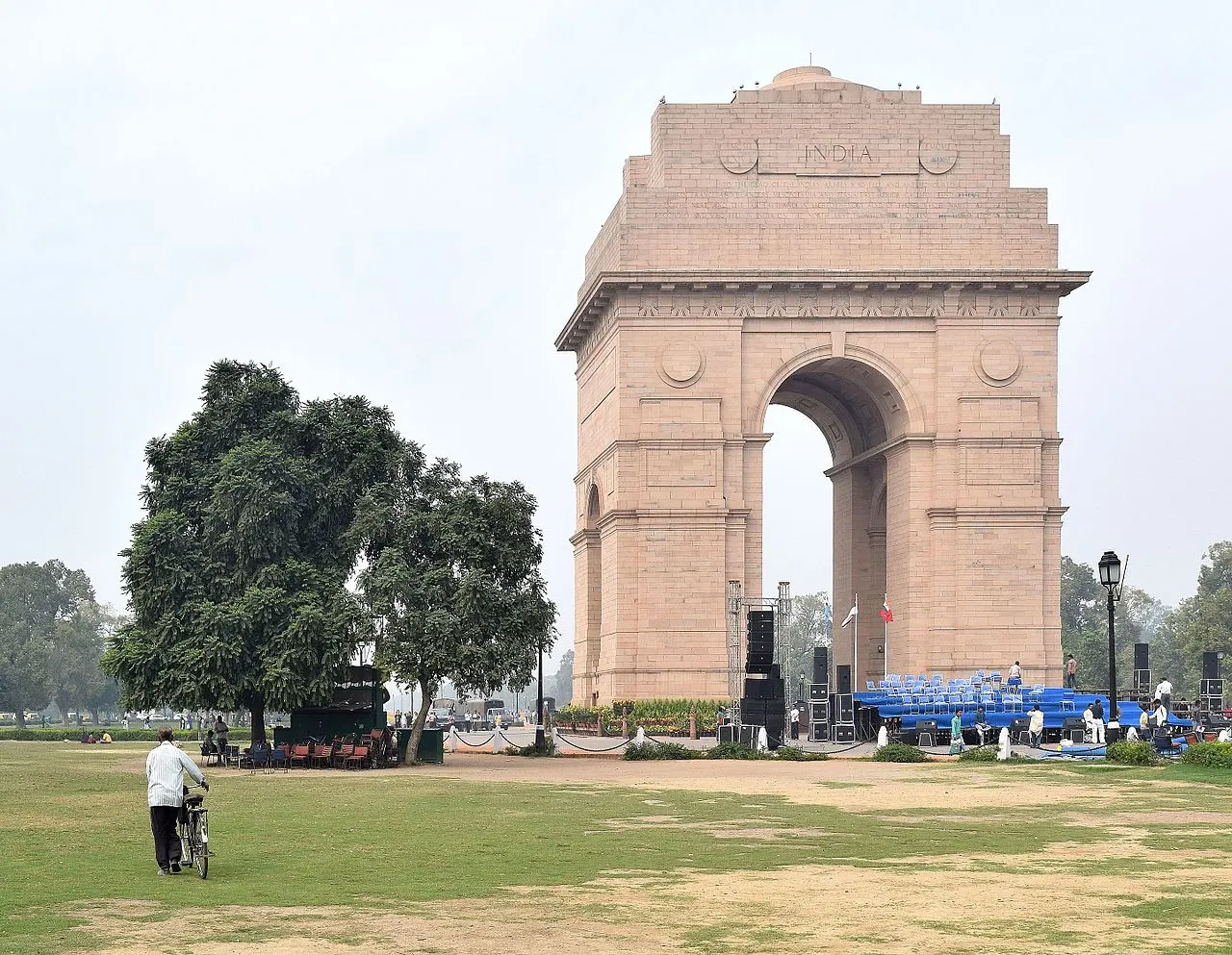 India Gate viewed across a lawn, with its monumental stone arch and inscribed upper facade