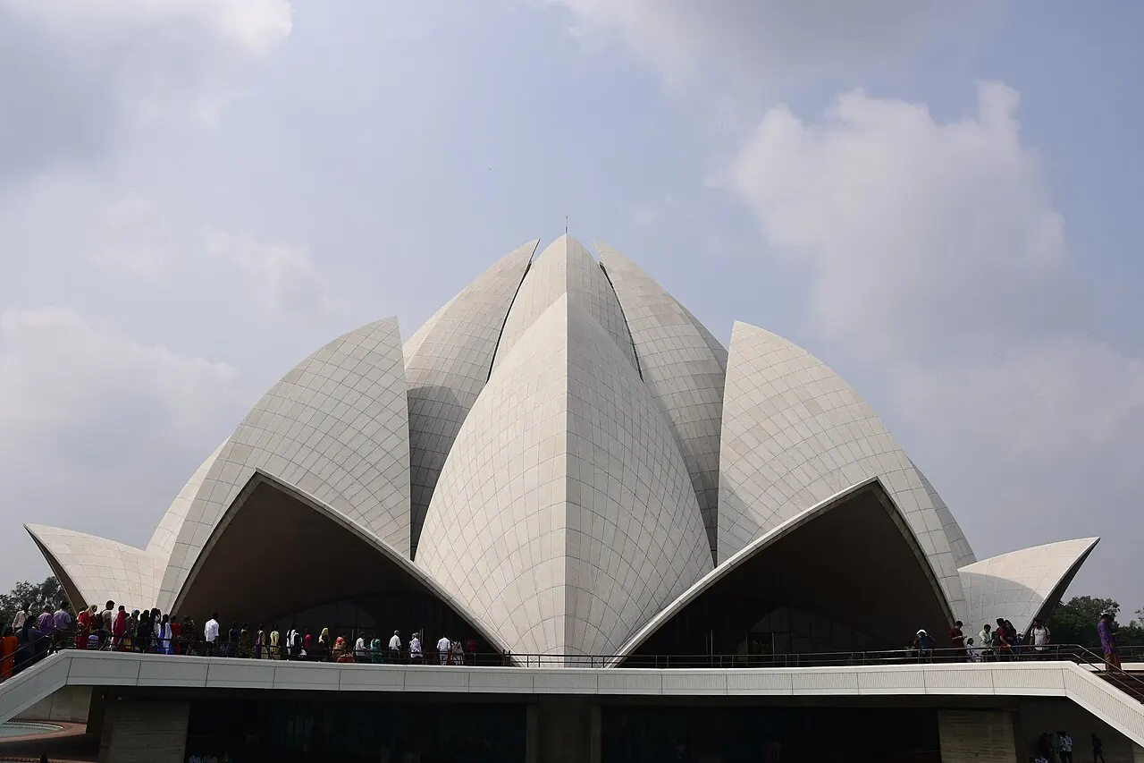 The white marble petals of the Lotus Temple above its approach and reflecting pool