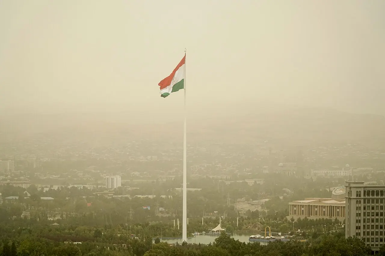 Der hohe Fahnenmast von Duschanbe mit der Nationalflagge über gestalteter Parklandschaft