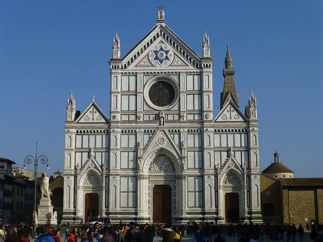The patterned marble facade of the Basilica of Santa Croce facing its square