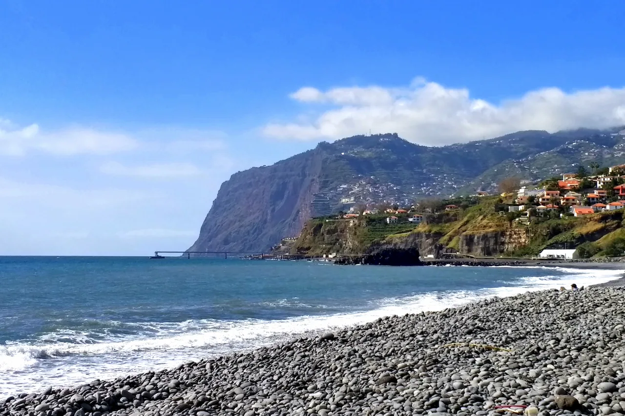 Dark pebbles and the Atlantic shore at Praia Formosa