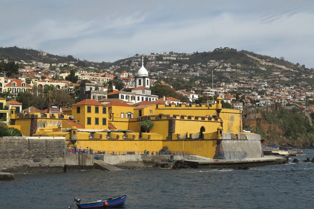 The yellow walls of Sao Tiago fortress by the sea
