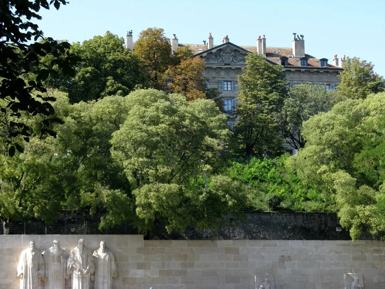 Reformation Wall behind the trees and paths of Geneva’s Parc des Bastions