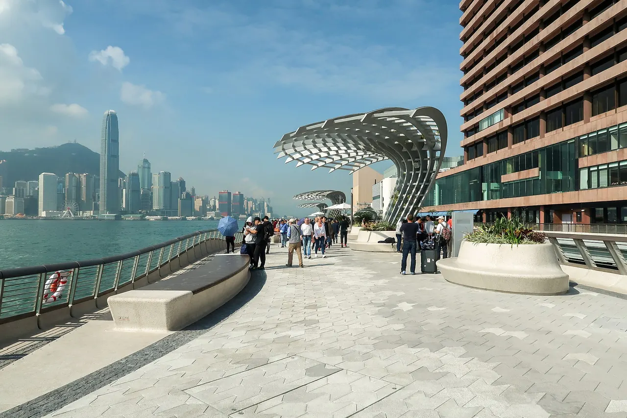 Visitors on the Avenue of Stars waterfront promenade facing Victoria Harbour