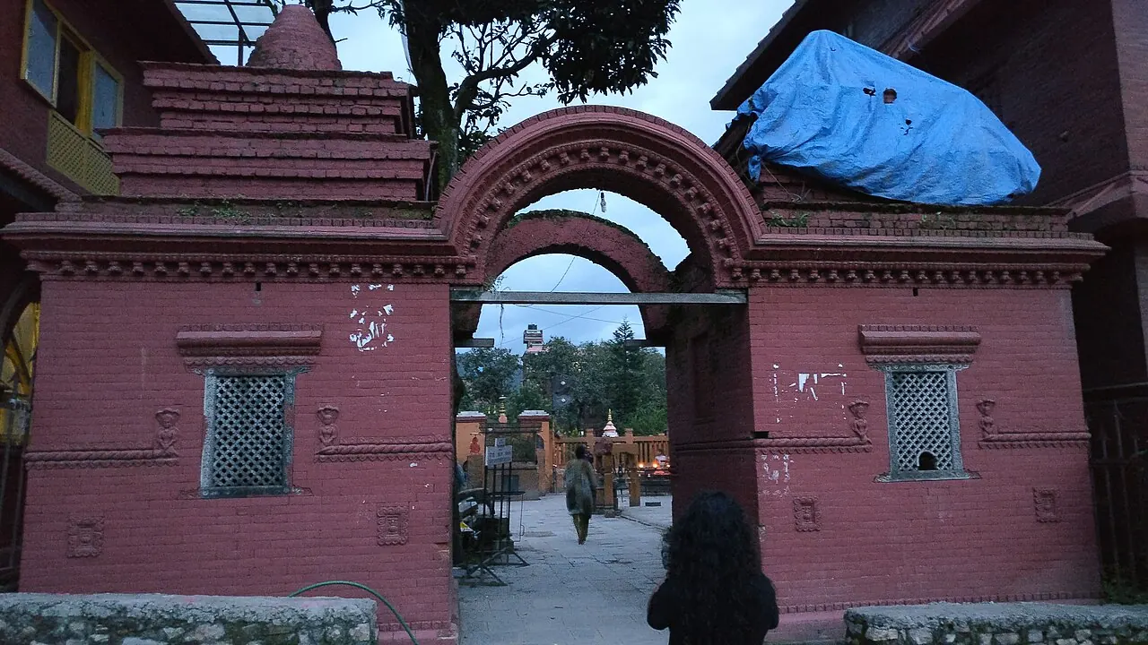 The pink gateway and visitor path at Budhanilkantha Temple