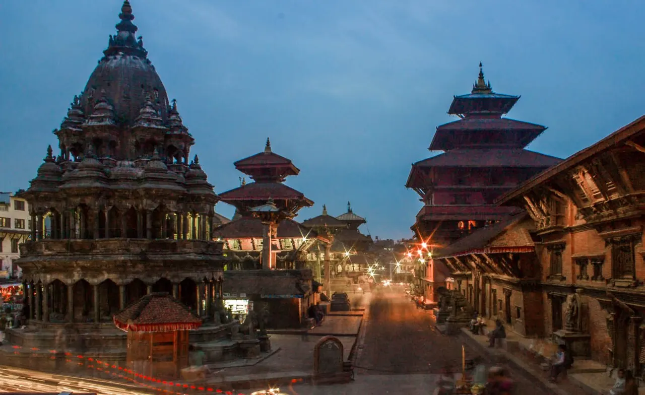 Patan Durbar Square's stone temple and pagodas lit at dusk