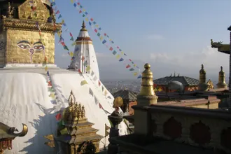 Swayambhunath's white stupa, golden shrines and prayer flags above Kathmandu