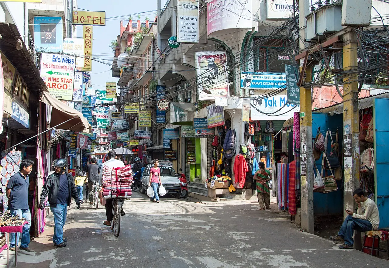 Shops, signs and pedestrians on a narrow street in Thamel