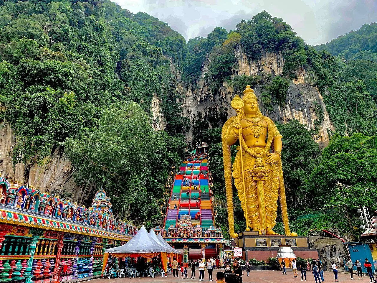 Colourful staircase rising to Batu Caves beneath the limestone cliff