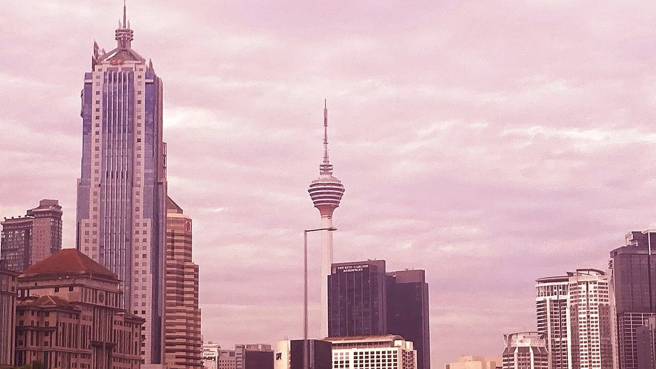 KL Tower rising above surrounding greenery and Kuala Lumpur buildings