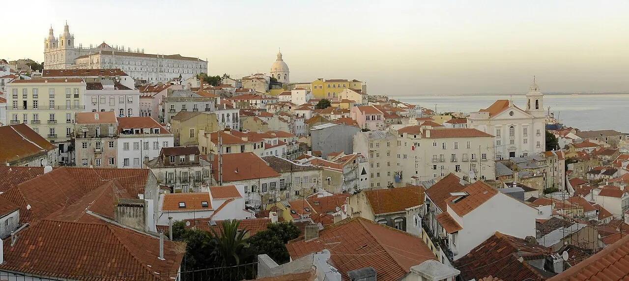 Alfama's tightly grouped tiled roofs and streets overlooking the Tagus