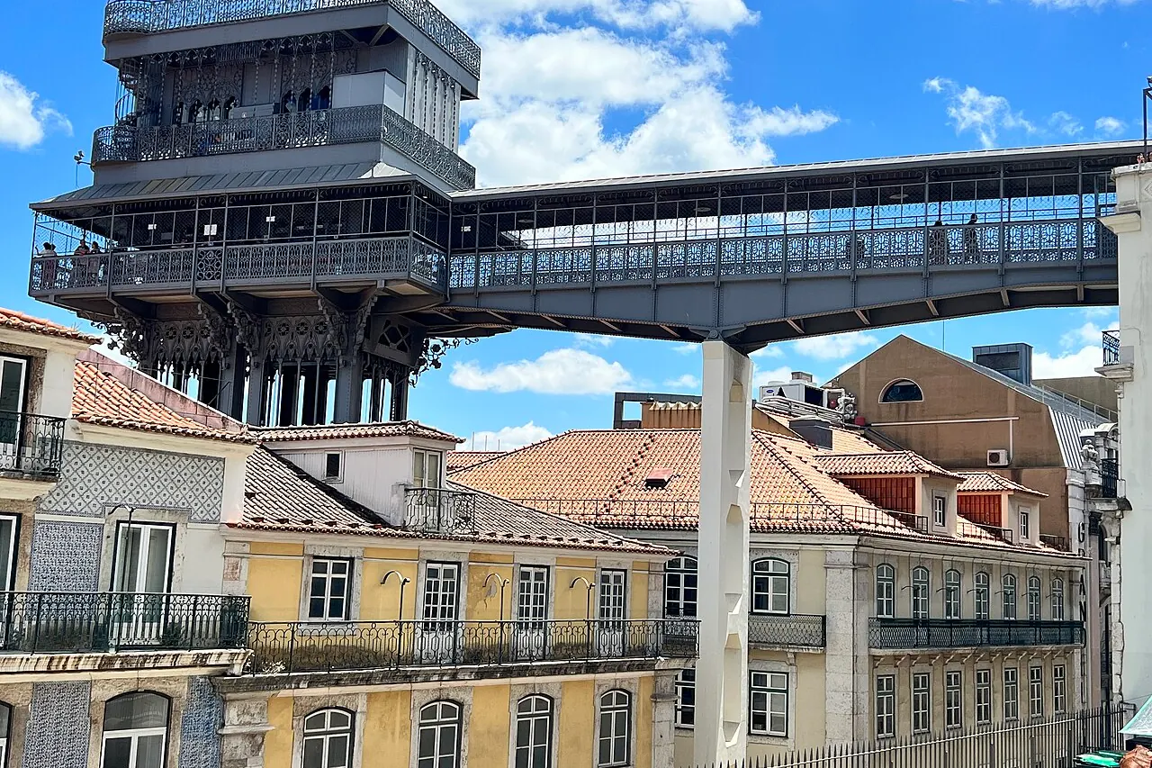 Santa Justa's decorated iron tower and elevated walkway above Lisbon's tiled roofs