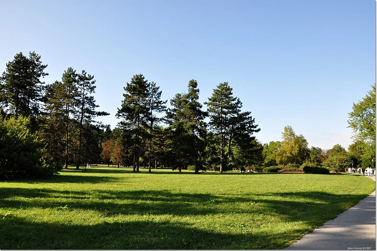 Open lawns and mature trees beside a path in Tivoli Park, Ljubljana