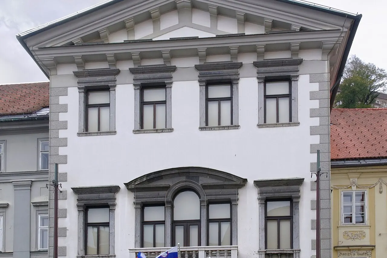 The clock tower and pale facade of Ljubljana Town Hall on Mestni trg