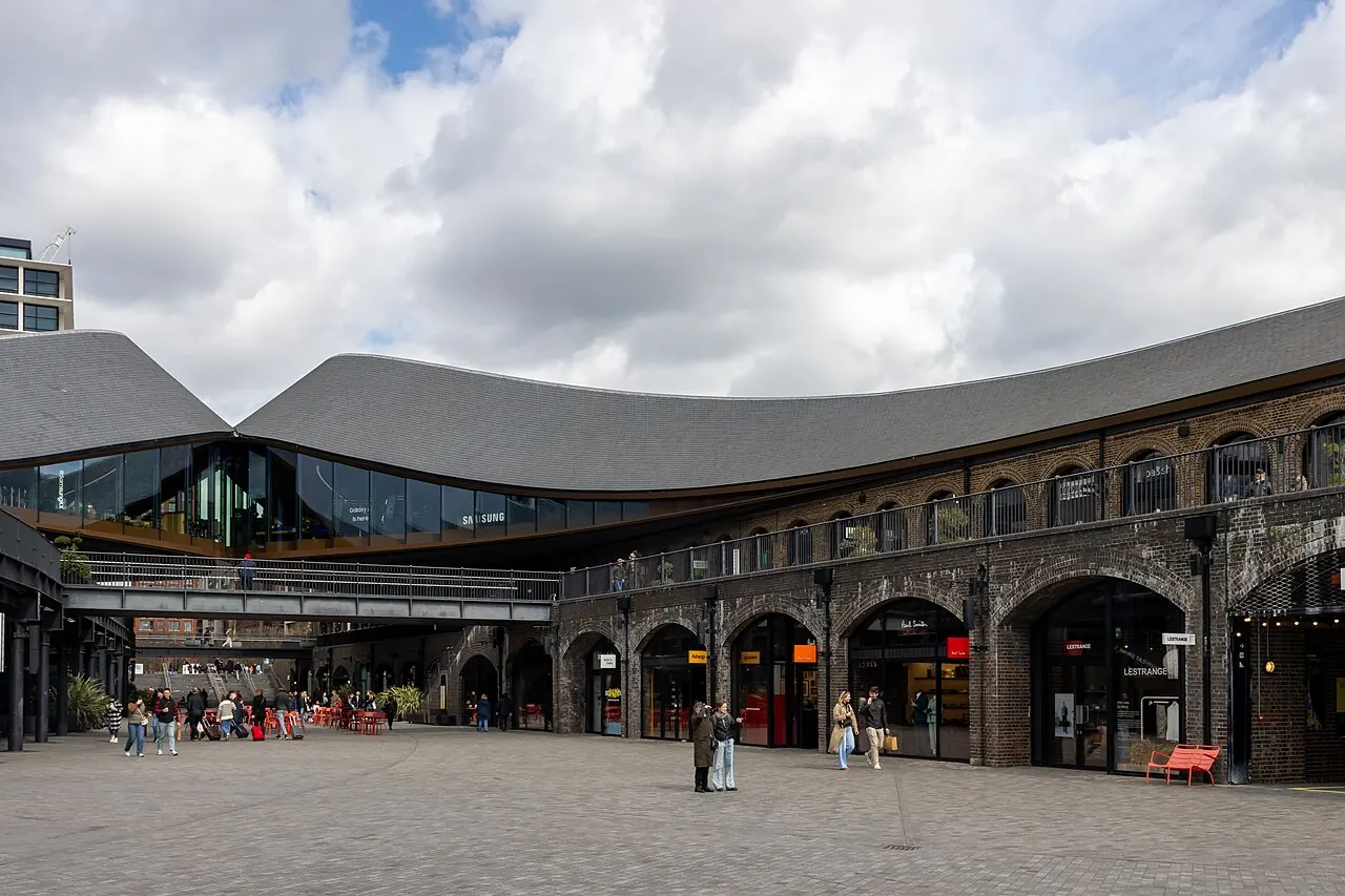 Shops and public courtyard beneath the curved roofs of Coal Drops Yard at King's Cross