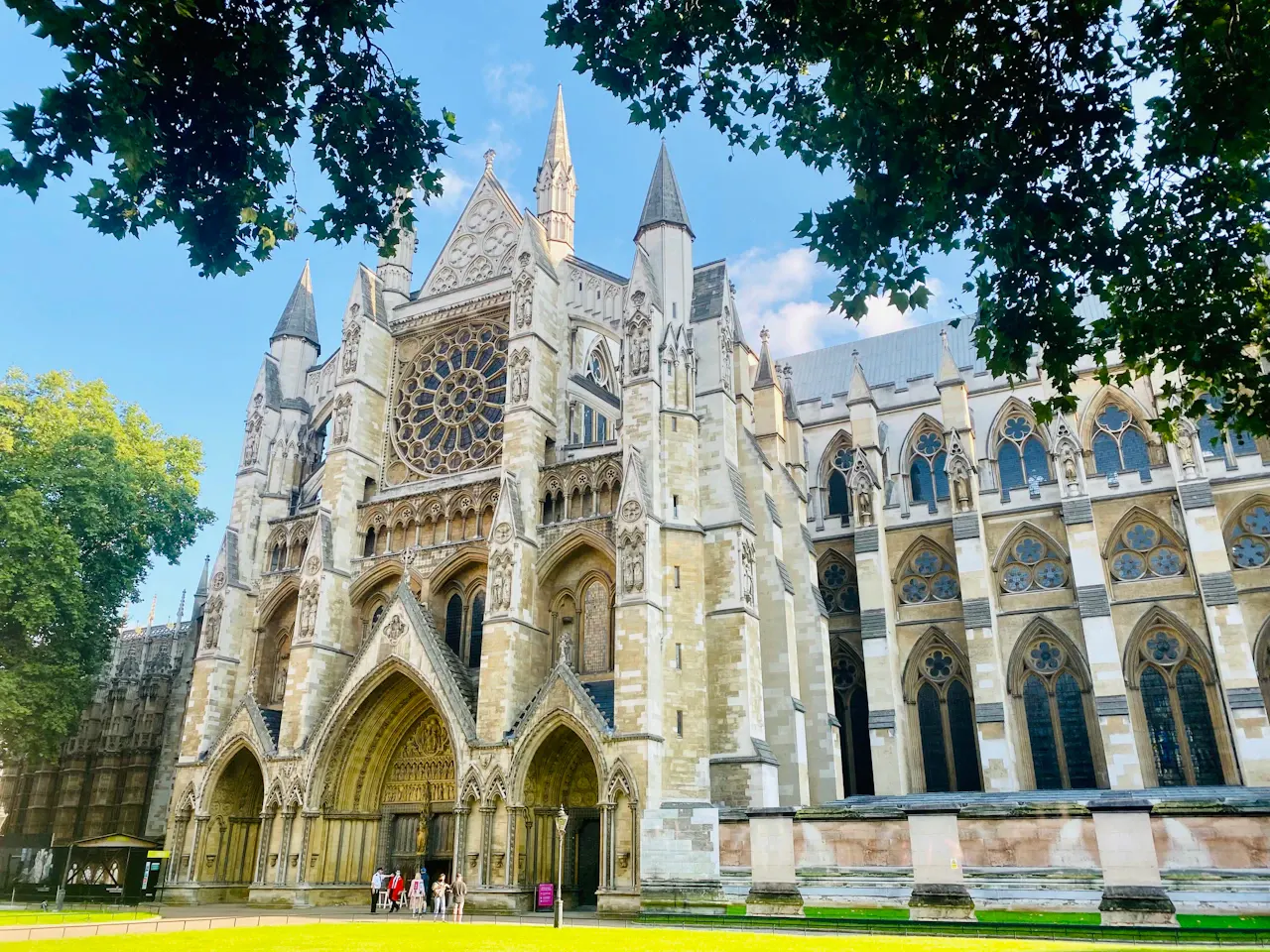 Westminster Abbey north entrance and rose window framed by leafy trees