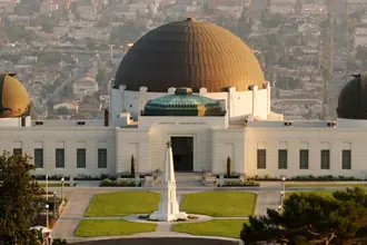 Griffith Observatory domes and white facade with Los Angeles visible behind