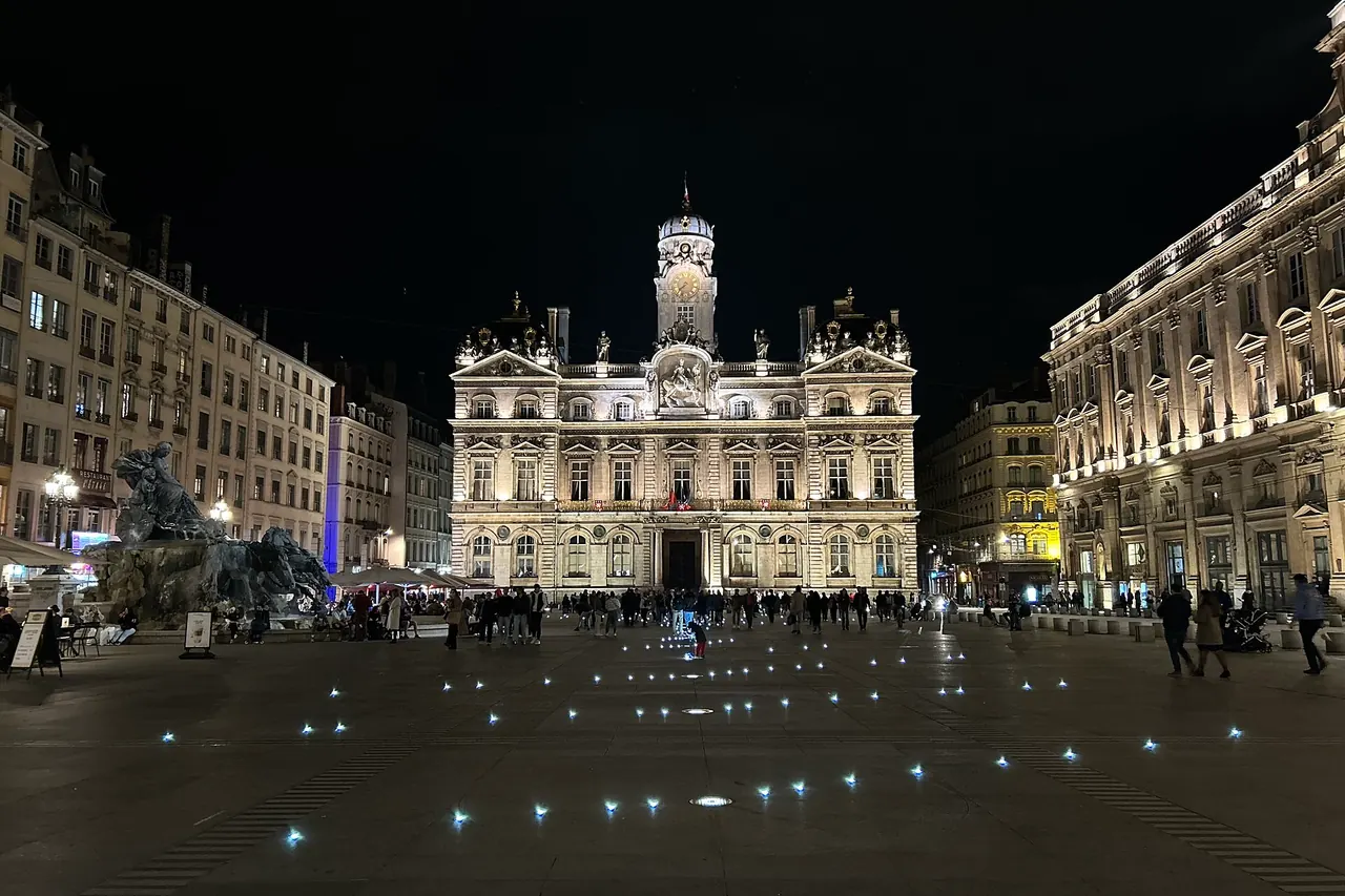 Place des Terreaux at night with the Bartholdi fountain and illuminated city hall in Lyon