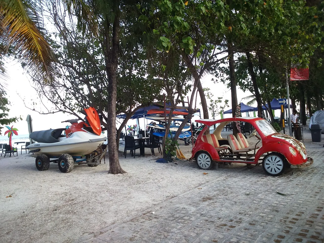 The shaded beach edge, small boats and nearby street at Hulhumale