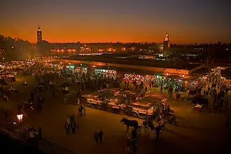 Food stalls, people and lights filling Jemaa el-Fnaa square after dark
