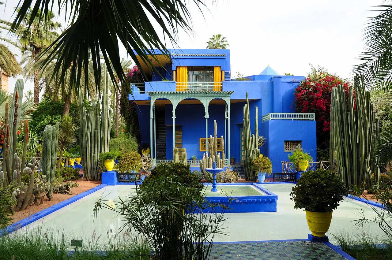 Blue garden architecture surrounded by palms and plants at Jardin Majorelle