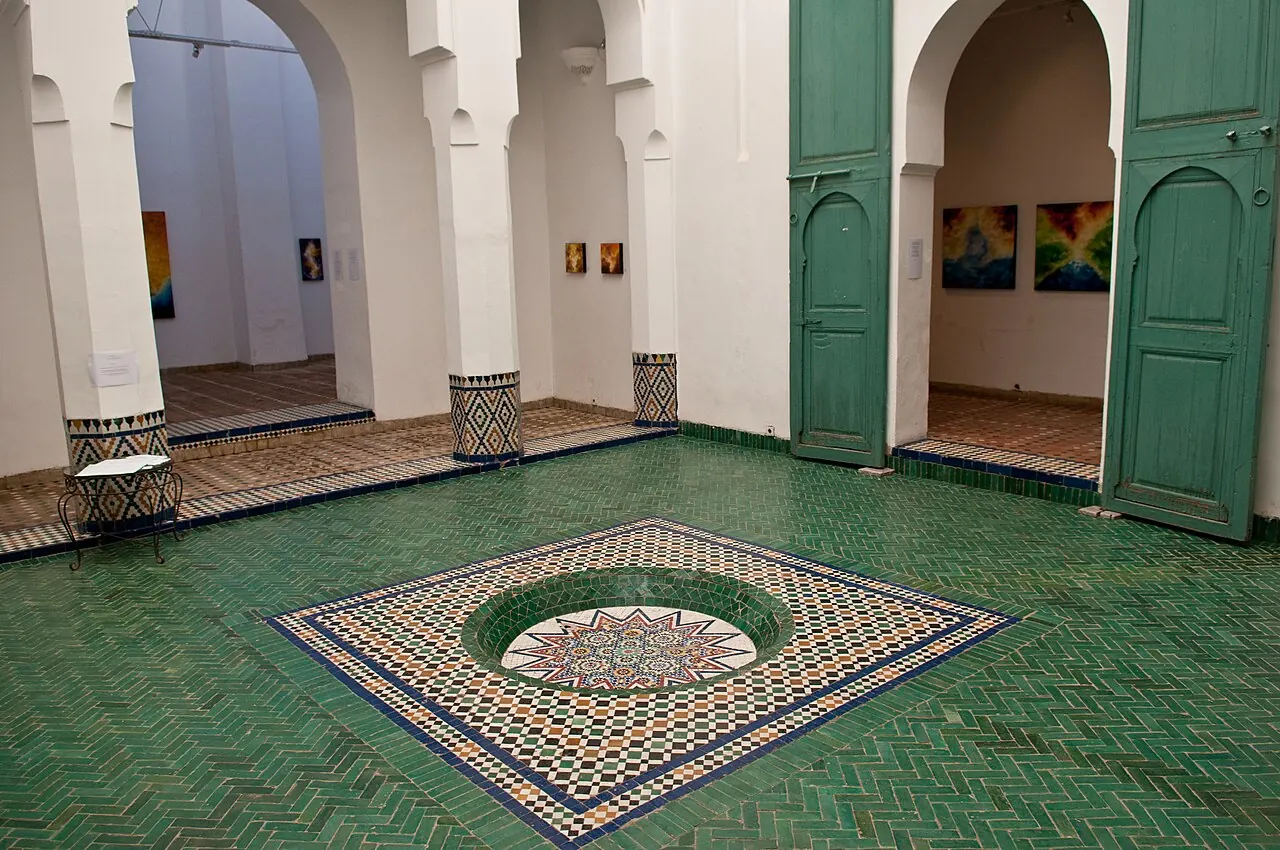 Tiled floors, white arches and green doors inside Marrakech Museum