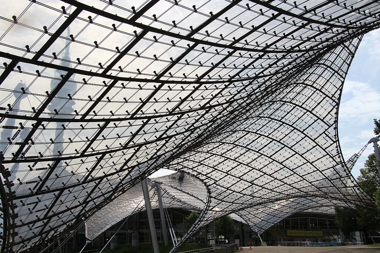 The cable-supported transparent roof of Munich's Olympic Park with the tower behind