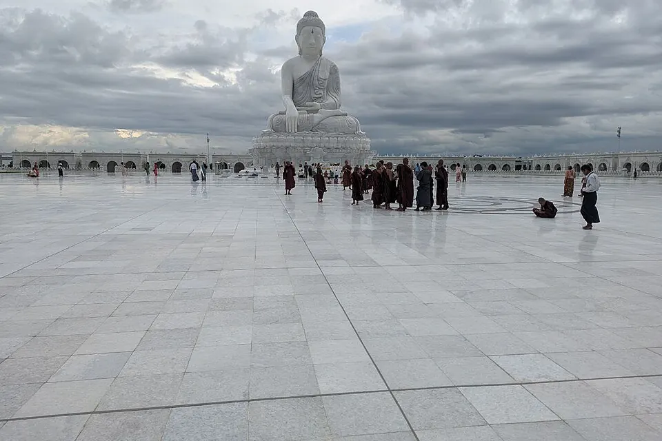The white seated Maravijaya Buddha image above a broad paved religious precinct
