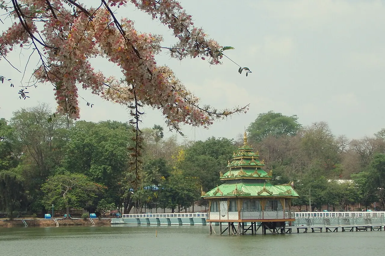 A green-roofed pavilion, trees and roadside buildings in Pyinmana