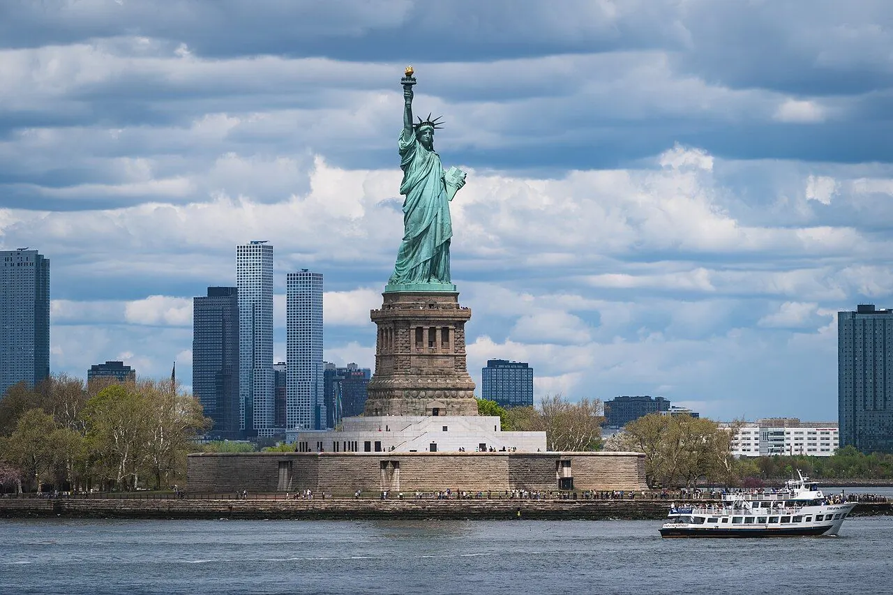 The Statue of Liberty on Liberty Island with a sightseeing boat on the harbour