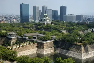 Osaka Castle keep above its stone ramparts and surrounding trees