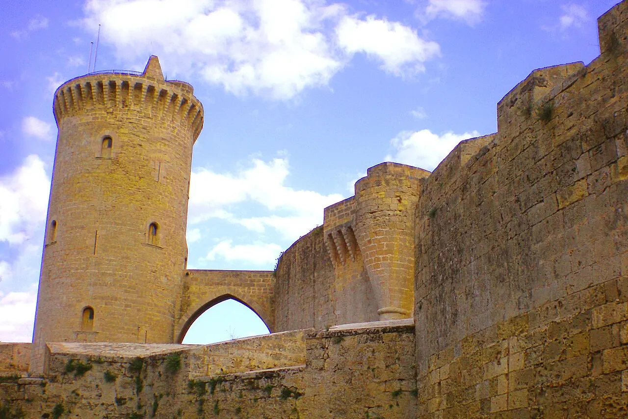 Der steinerne Bergfried und die Bogenbrücke von Castell de Bellver, von den Außenmauern aus gesehen