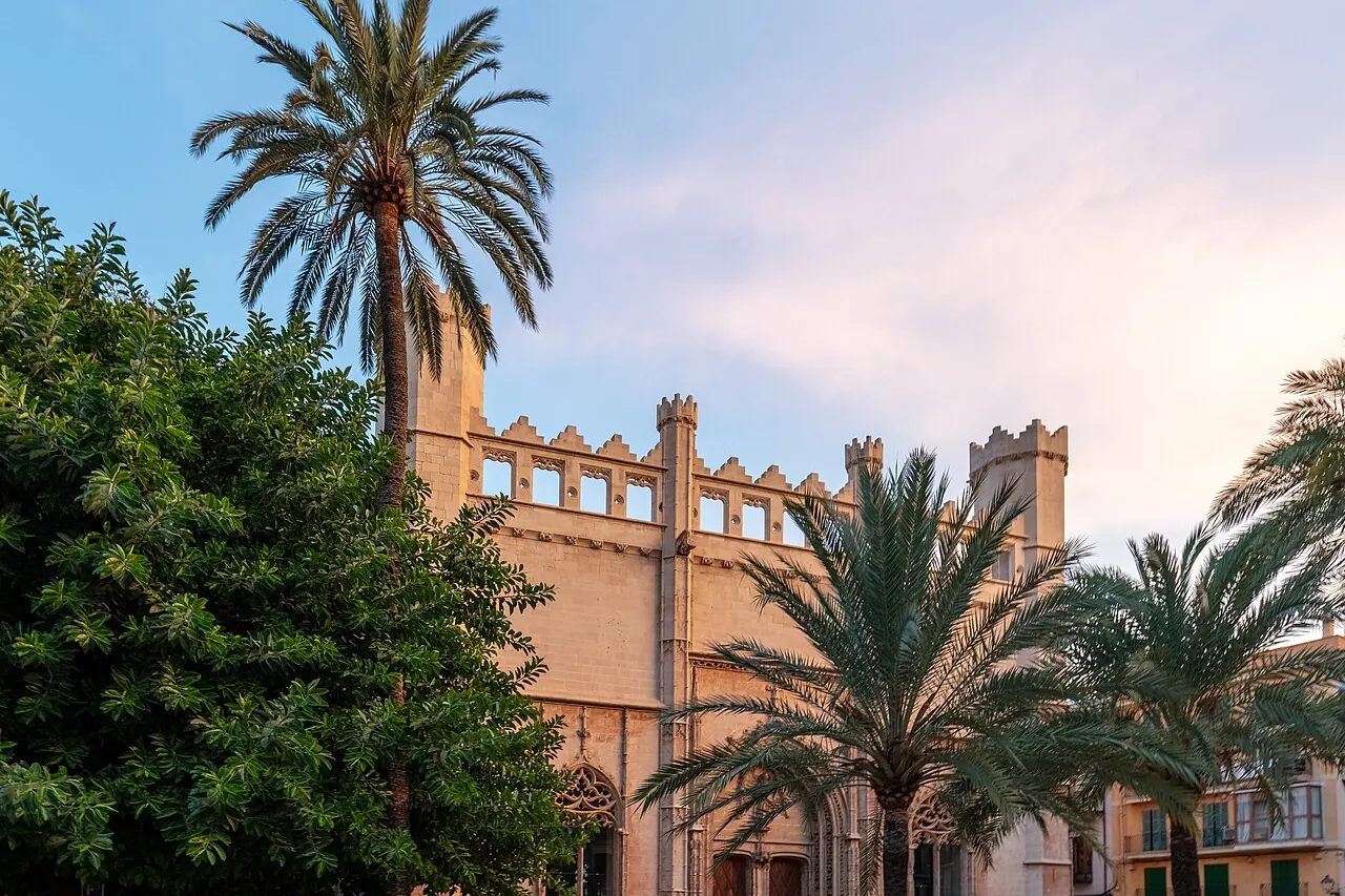 Die Steinfassade von La Llotja in Palma, eingerahmt von Palmen